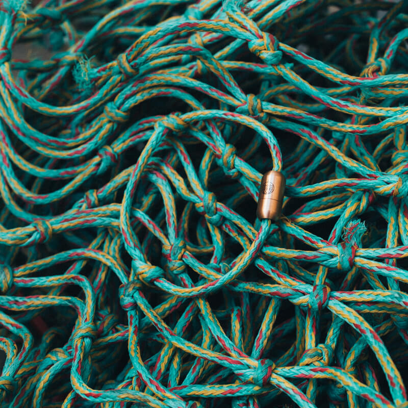 Caribbean Sea Bracenet liegt auf dem Fischernetz, aus dem es gefertigt wurde.