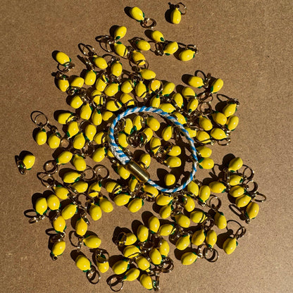 Almalfi Bracenet Bracelet aus Fischernetz in weiß und blau mit Edelstahl Magnetverschluss und einem Zitronenanhänger. Weitere viele Zitronenanhänger