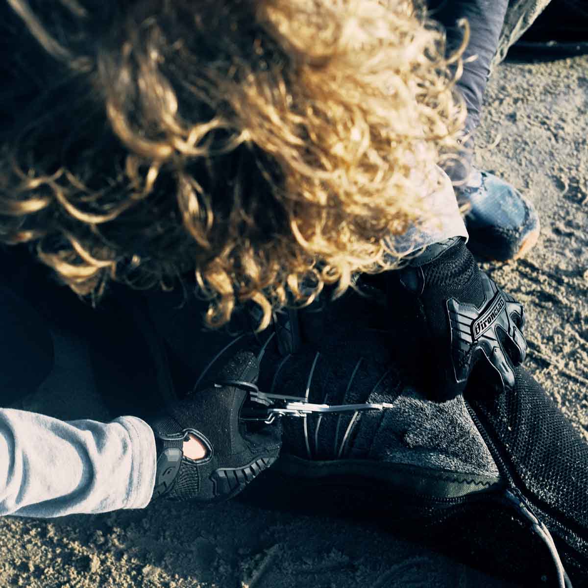 Malte Zierden schneidet am Strand eine Robbe aus den Langleinen frei.