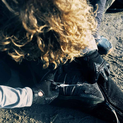 Malte Zierden schneidet am Strand eine Robbe aus den Langleinen frei.