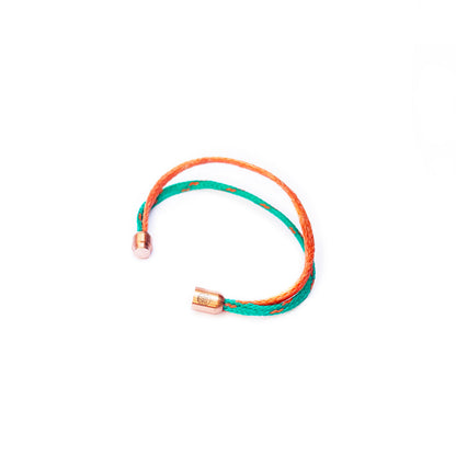 August Bracenet Phuket Armband aus Fischernetz mit einem Strang Fischernetz in Grün mit Highlights in Orange, einem Strang Fischernetz in Orange und einem Magnetverschluss in Roségold.