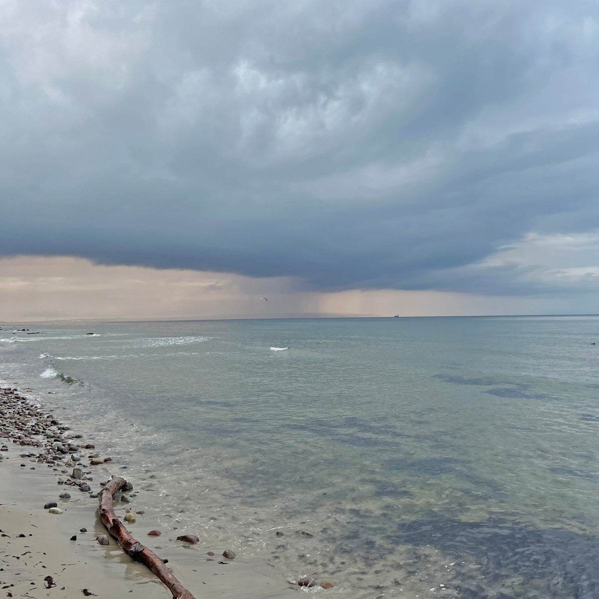 Strandaufnahme von der Insel mit Blick aufs Meer. Es sind Wolken am Himmel. 