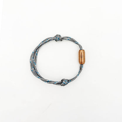 Das größenverstellbare Baltic Sea Bracenet, gefertigt aus alten Fischernetzen in Grau mit Punkten in Blau und Weiß und mit Bajonettverschluss in Roségold.