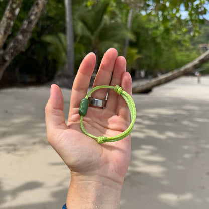 Person hält das Juni Bracenet Bismarck Sea aus Fischernetz in Hellgrün mit Magnetverschluss aus eingeschmolzenen Fischernetzen in Grün in der Hand. 