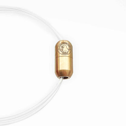 Alles für die Tiere immer - Robbe "Walvis" Armband aus transparenten Langleinen von BRACENET mit Drehverschluss in roségold und "Alles für die Tiere, immer" Gravur mit Robben-Motiv. Durch das Armband hindurch sieht man Malte Zierden, der in einer Hand das Produkt hält und in der anderen die unverarbeiteten Langleinen. 