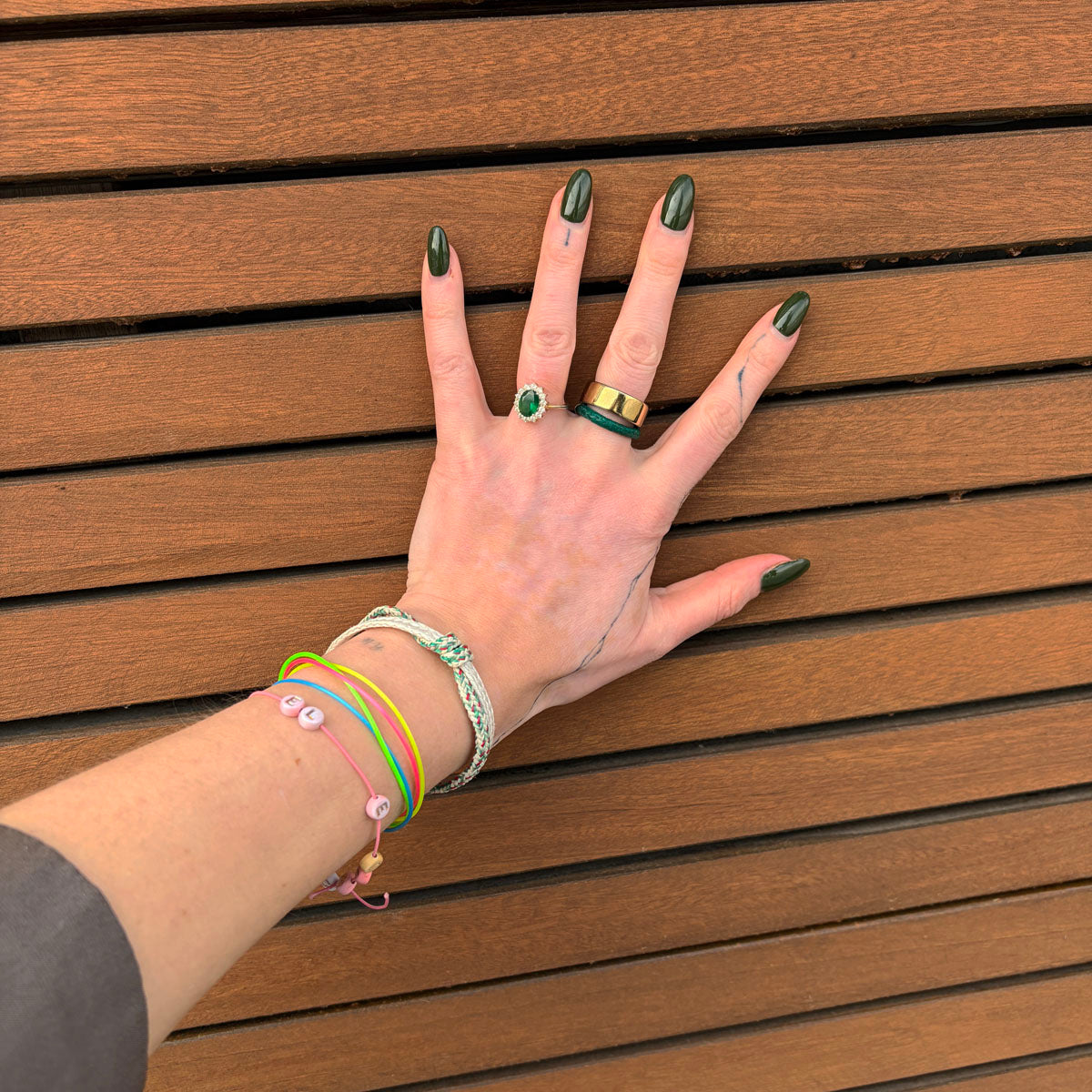 Person trägt das Enard Bay Bracenet aus Fischernetz in Weiß und Grün mit Umwicklung in der Mitte und mit Bajonettverschluss in Silber am Handgelenk.