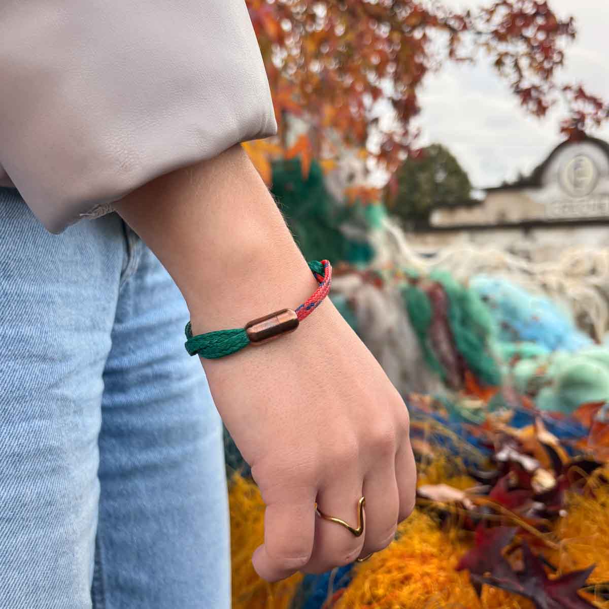 Person träagt das BRACENET Christmas Bracenet aus einem grünen und einem roten Fischernetz mit coffee Magnetverschluss am Handgelenk.
