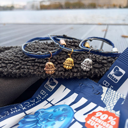 3 Nalu Bracenet Armbänder mit Quallen Anhänger in den Farben rosé, gold und ilber und im Vordergrund eine Nalu Tüte