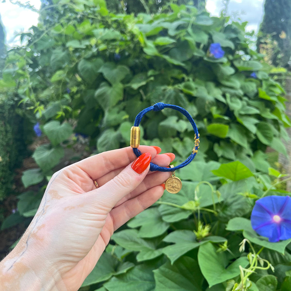 Sicilia, Sizilien Bracenet Bracelet aus Fischernetz in blau und gold mit Edelstahl Magnetverschluss und einem Medusa Anhänger in der Hand gehalten