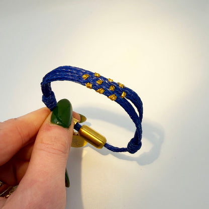 Sicilia, Sizilien Bracenet Bracelet aus Fischernetz in blau und gold mit Edelstahl Magnetverschluss und einem Medusa Anhänger in der Hand gehalten
