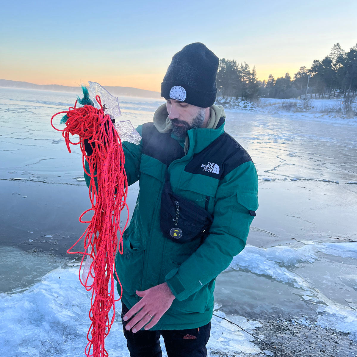Person hält das Gulf of Bothnia Fischernetz in Pink in der Hand nachdem es aus dem Meer geborgen wurde.