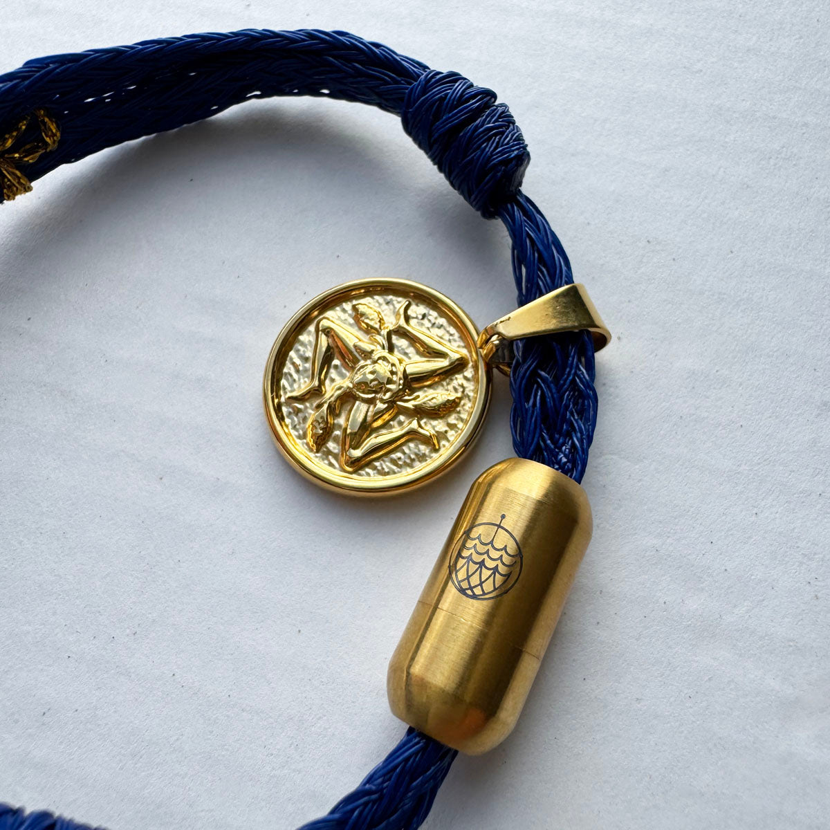 Sicilia, Sizilien Bracenet Bracelet aus Fischernetz in blau und gold mit Edelstahl Magnetverschluss und einem Medusa Anhänger als Freisteller Close Up Ansicht
