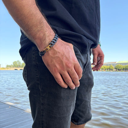 Person trägt das SeaChain Bracenet in 3D Druck aus alten Fischernetzen hergestellt in Schwarz mit kleinem Clip Karabiner in Gold am Handgelenk und hat die Hand in der Hosentasche.
