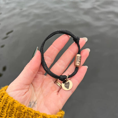 Person zeigt das Black Sea Armband von BRACENET und Malte, im Hintergrund die Alster