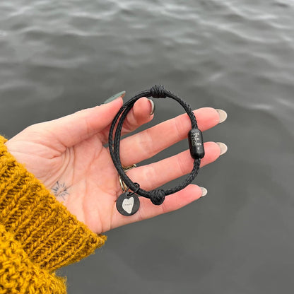 Person zeigt das Black Sea Armband von BRACENET und Malte, im Hintergrund die Alster