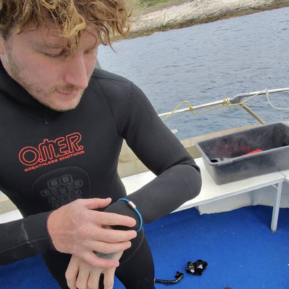 Malte Zierden auf einer Bergungsfahrt im Taucheranzug auf dem Boot in Kroation mit Healthy Seas