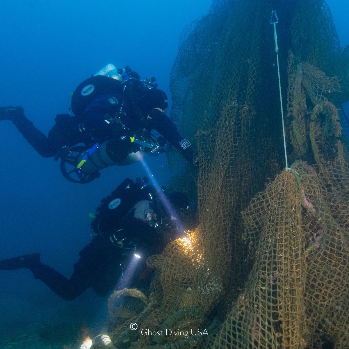 Zwei Taucher von Ghost Diving USA bergen ein altes orangenes Fischernetz im Meer vor Kalifornien zum Upcycling für BRACENET