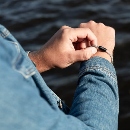 Person öffnet das handgefertigte Upcycling Armband Baltic Sea von BRACENET am Arm