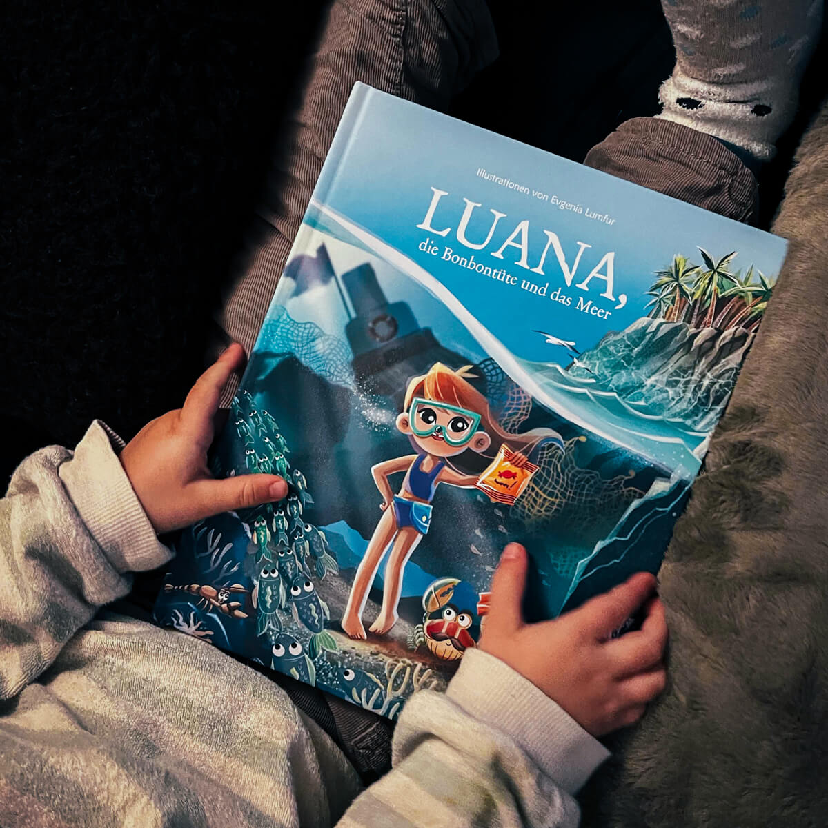 Kind hält das Luana Kinderbuch von BRACENET in den Händen