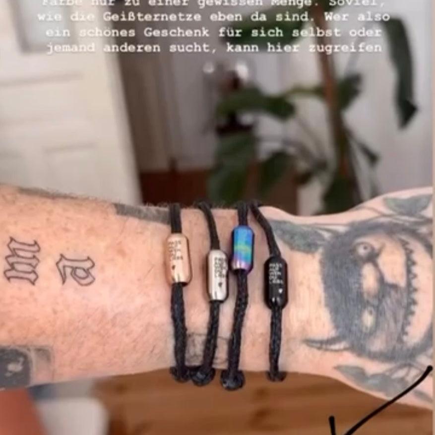 Malte zeigt alle schwarzen PAWDL Upcycling Armbänder von BRACENET am Arm