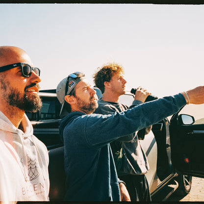 Malte Zierden und Benjamin von BRACENET stehen mit einer weiteren Person vor einem Auto und beobachten die Robben mit einem Fernglas.