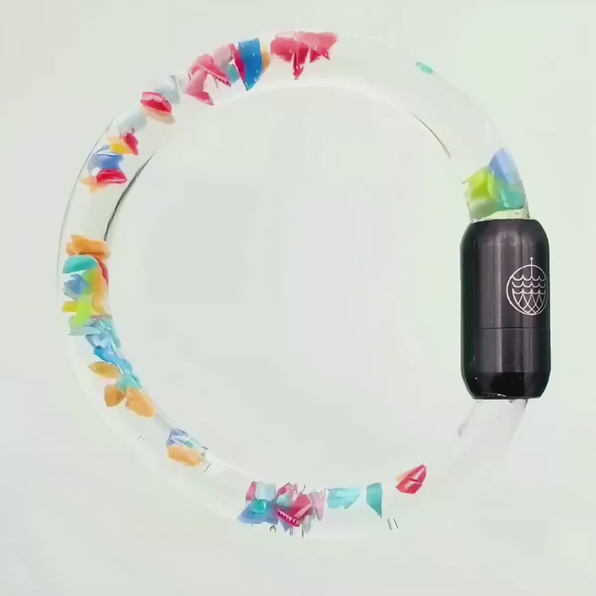 Video von dem BRACENET Floating Upcycling Armband aus alten Plastiktuben gefüllt mit Mikroplastik, destilliertem Wasser und Glycerin mit magnetischem Edelstahlverschluss in schwarz in dem man sieht, dass die Plastikstücke schweben
